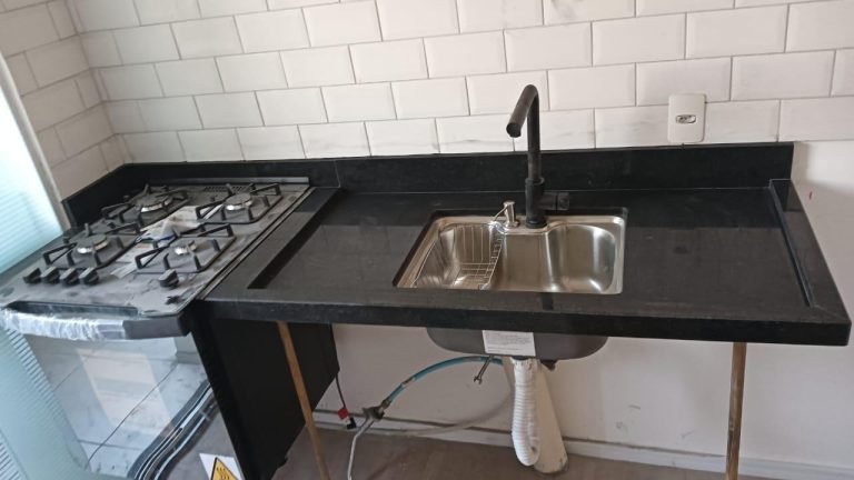 Bancada de cozinha em granito preto com cooktop e cuba de inox